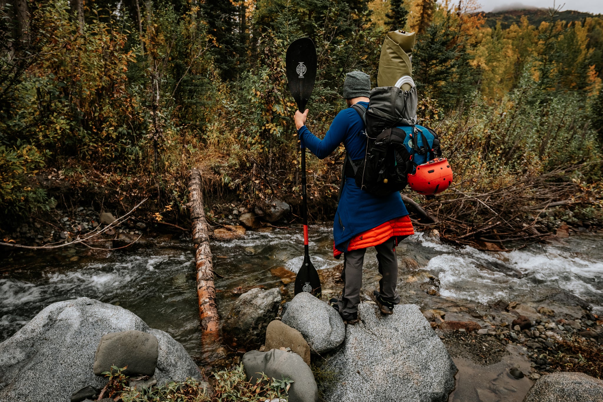 Nick Coulter crossing a stream on a backpacking paddle trip