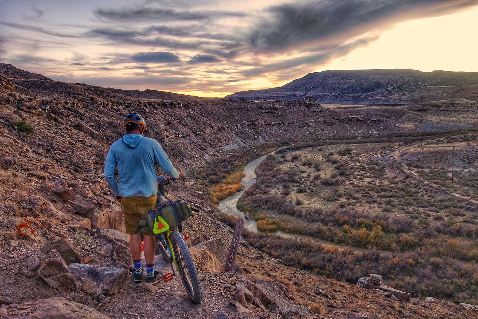 Bikerafting the American West - Bike rider overlooking a canyonland sunset