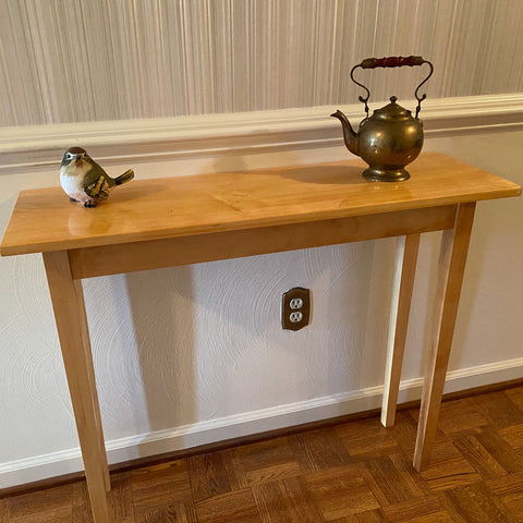 Maple console table with a bird figurine and teapot on display