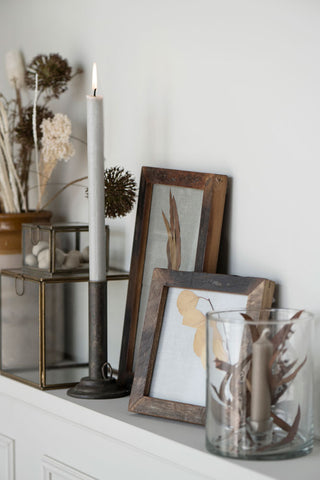 alt="Collection of Danish candles and natural wood photo frames"