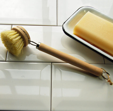alt="beech handled dish cleaning brush on draining board"