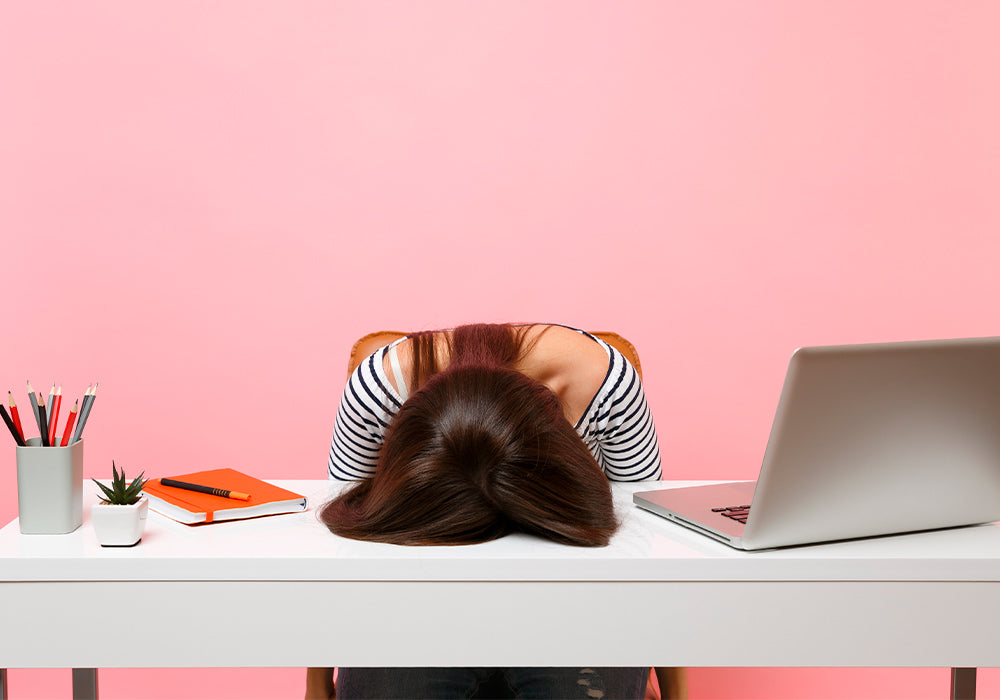 Woman with her head lying on her desk