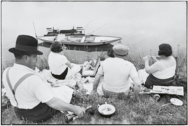 Henri Cartier-Bresson, Picnic on the Banks of the Marne, 1938. Black and white image of four people enjoying a picnic on the banks of the river Marne, France.