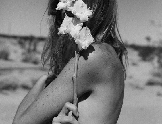 woman holding flower in black and white