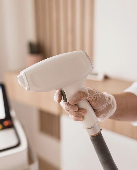 Hand with glove holding a laser