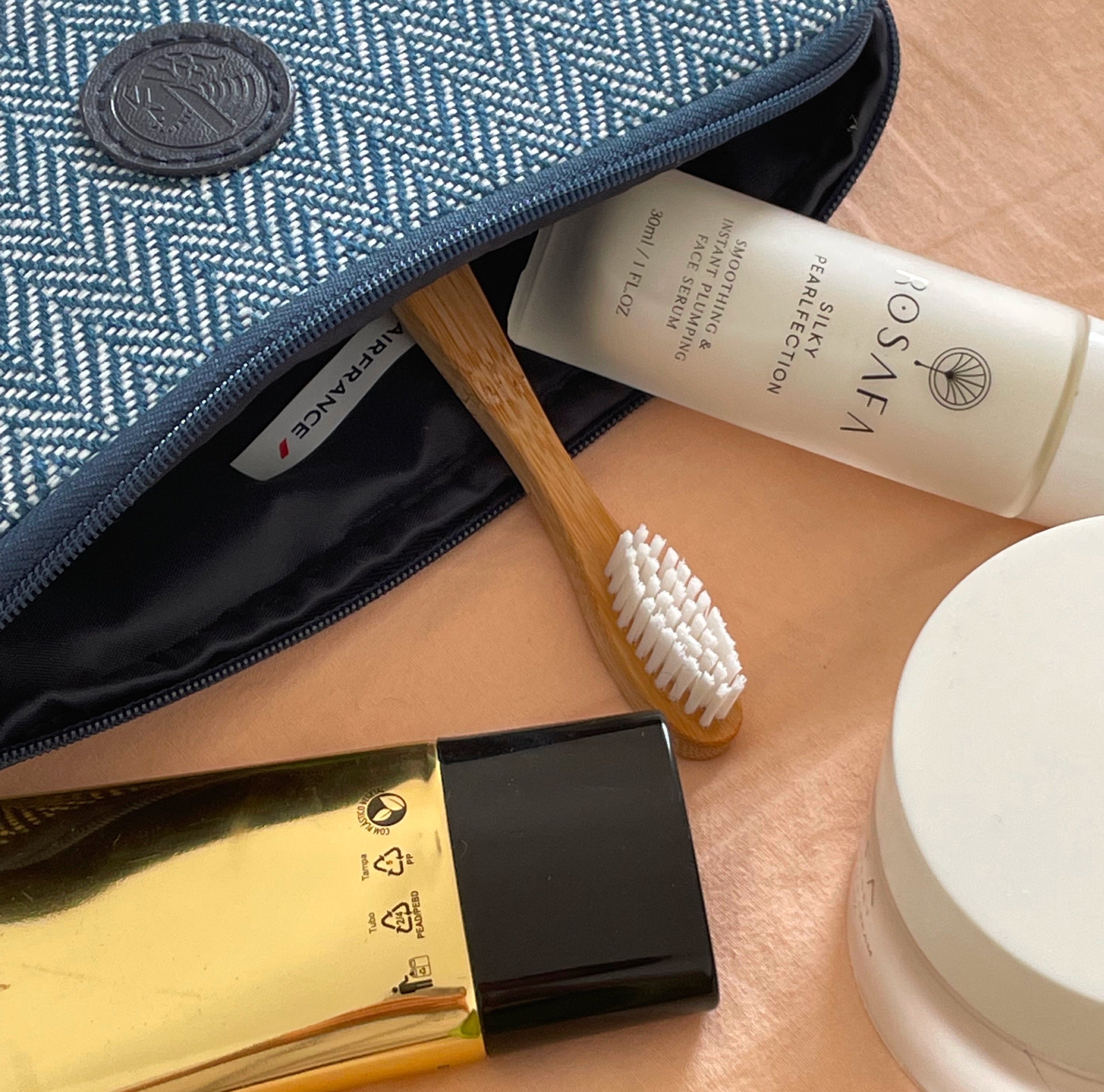 Rosafa face serum next to the toothbrush in a travel bag