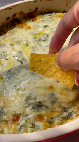 image of spinach artichoke dip and a tortilla chip