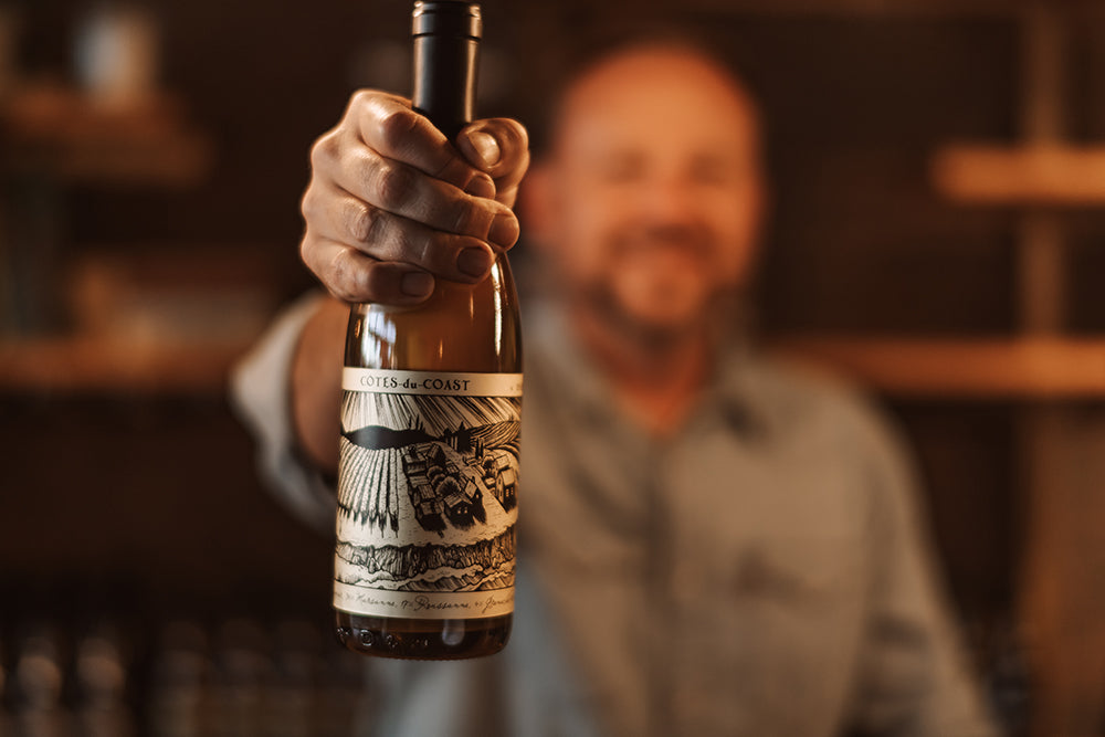 Curt holding bottle of wine at Sans Liege