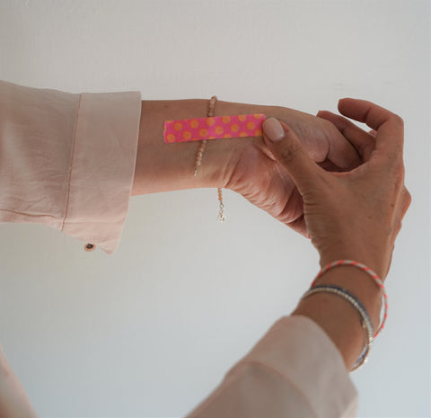 Armband mit einem Klebestreifen auf dem Arm befestigen