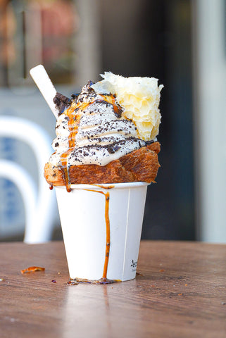 Delicious Dirtea Softserve - A swirl of creamy Assam Milk Tea Softserve, drizzled with brown sugar syrup and topped with generous Oreo crumbs, served in a Luna Bakehouse croissant cone.