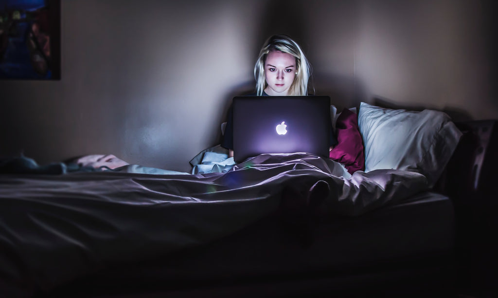 Mujer con ordenador investigando sobre la parálisis del sueño