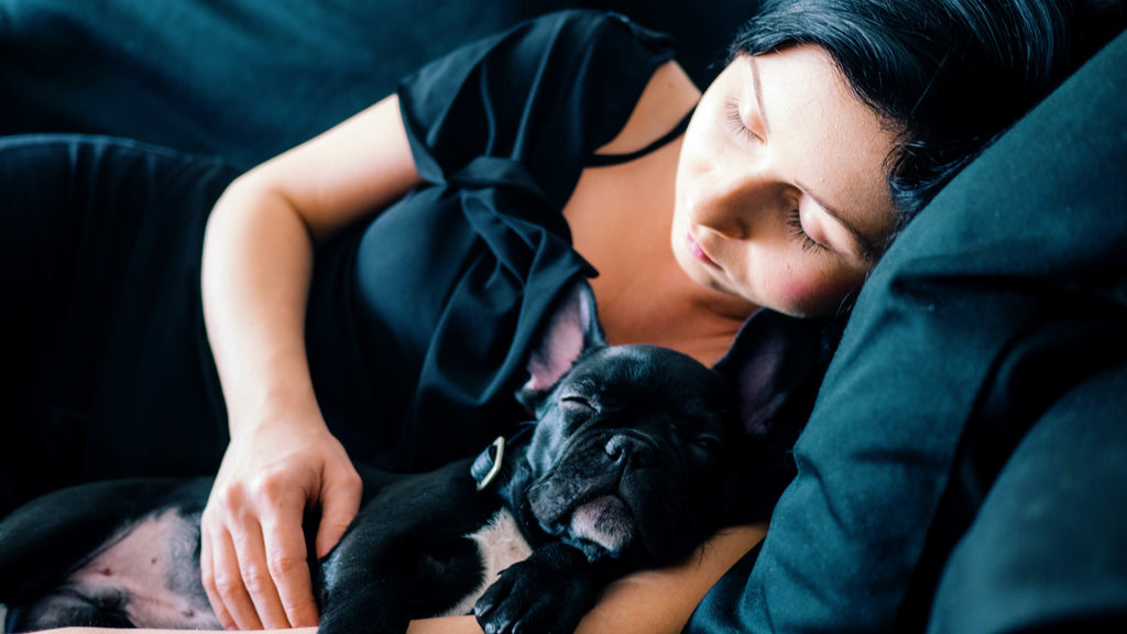 Posturas para dormir: mujer durmiendo con bulldog