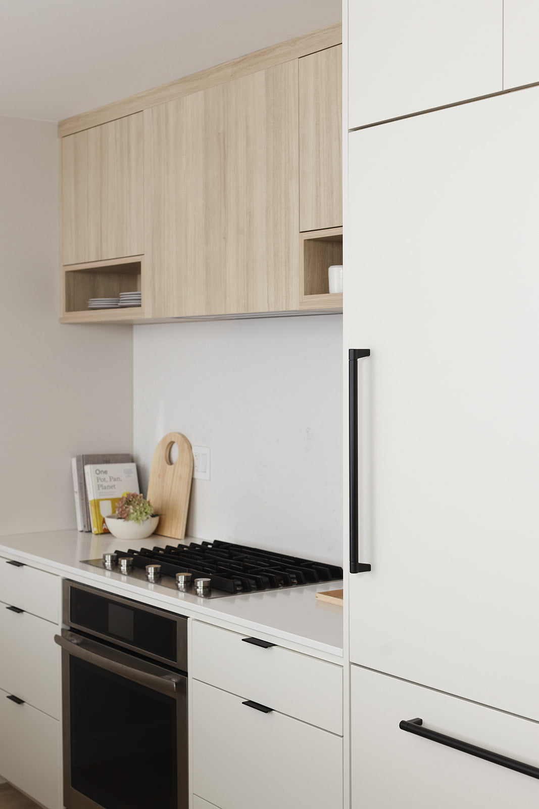 off white flat front swede kitchen with matte black hardware integrated fridge designed by studio hemma