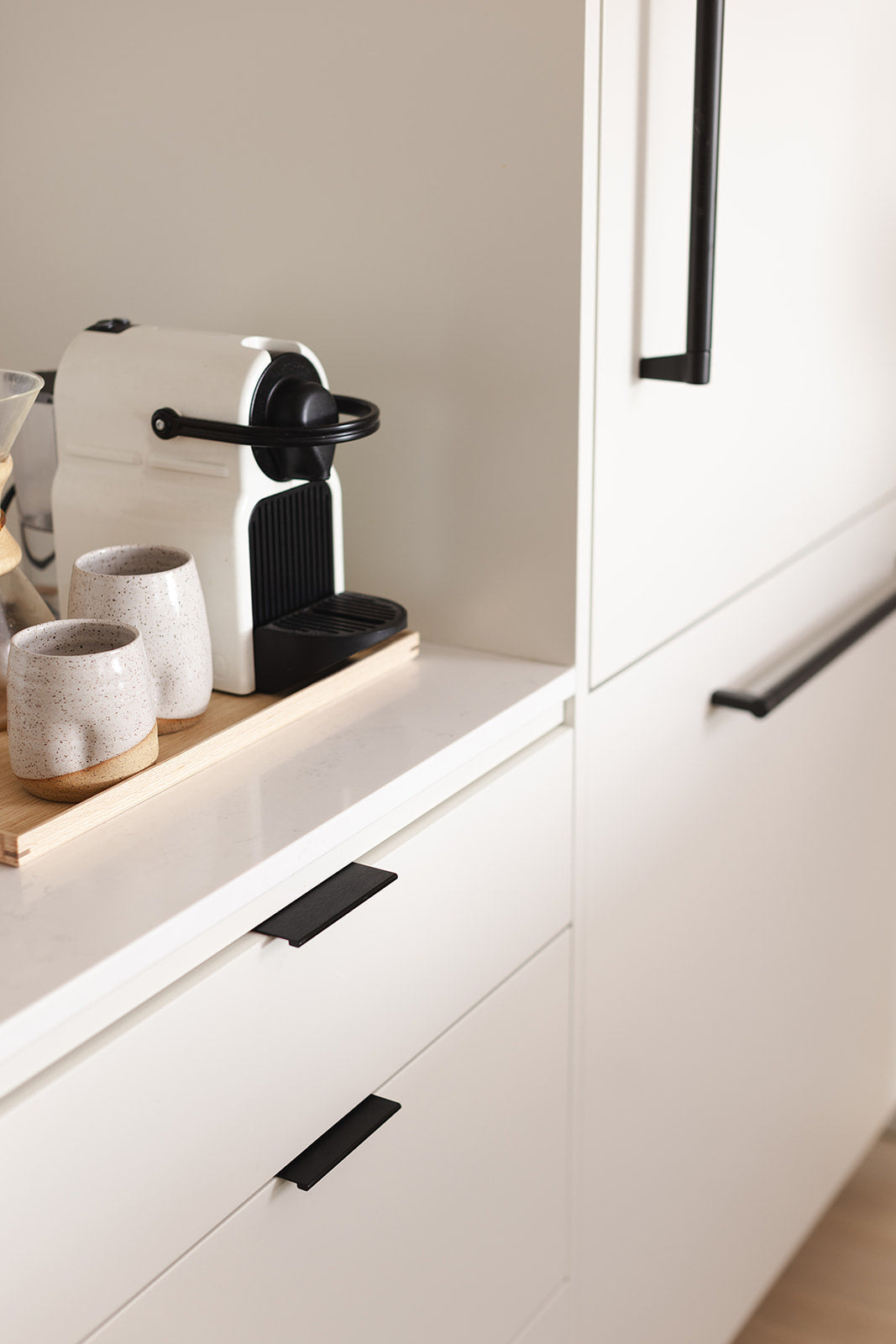 off white flat front swede kitchen with matte black hardware integrated fridge designed by studio hemma