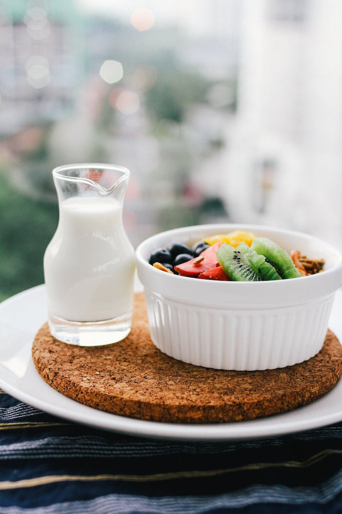 Why is camel milk so expensive? A glass of camel milk next to a nutritious bowl of colorful fruit. 