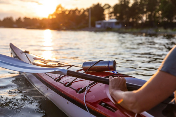 View of a person's arm in a kayak on the water facing the sun