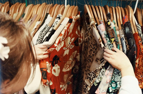 Brunette woman sifting through the clothes in her closet