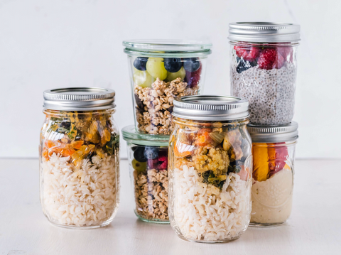 a collection of jar plant-based meals like grain bowls, chia pudding, and oatmeal with fruit