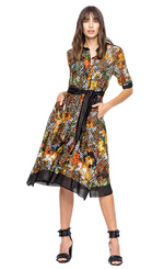 Load image into Gallery viewer, front full body view of a woman wearing closed the beate heymann colorful blouse dress. This dress has a button down front, elbow length sleeves and sits at the knees. The dress has a multicolor floral print with black chevron mixed in. The hem has black striped detailing. The dress also has a black striped tie belt at the waist.
