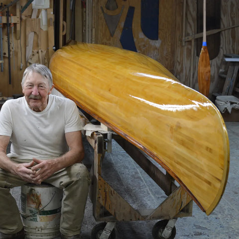 Portrait of Phil Pike sitting beside canoe