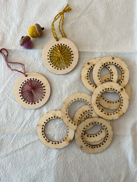 small circular wood looms threaded with wool yarn