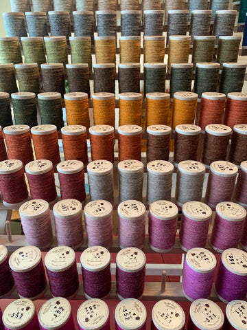 rack of wood spools of wood threads in many colors