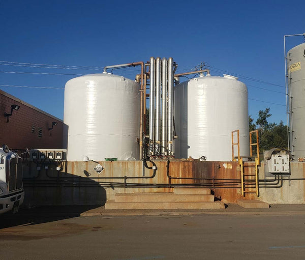 large white outdoor industrial storage tanks after a fresh coat of paint and sealer