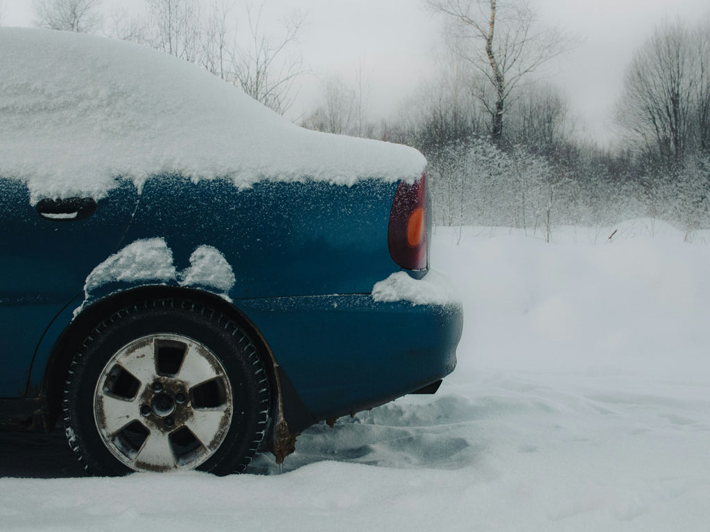 Car covered in snow highlighting the importance of proper winter tire pressure for safe driving.