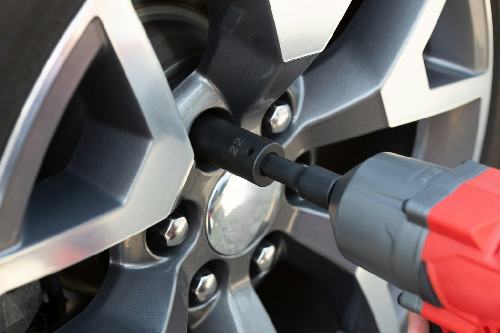 Close-up of a tire pressure gauge checking car wheel, emphasizing regular tire maintenance for safety.
