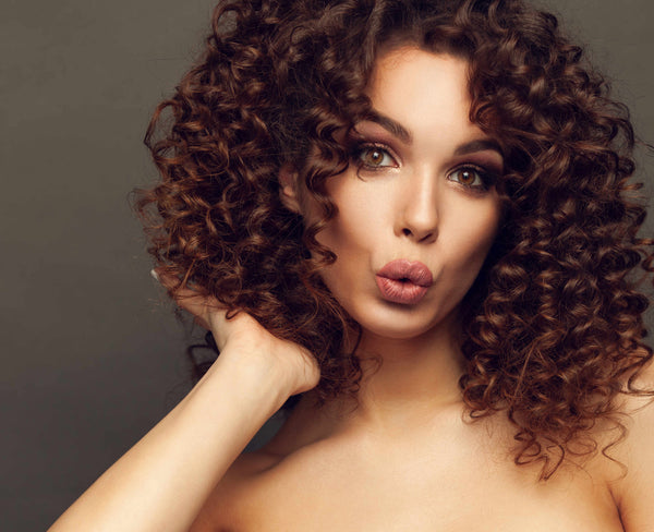 Young woman with puckered lips and hair on curly locks