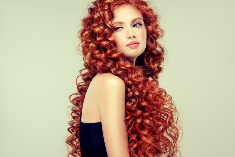 Beautiful curly haired red headed woman in a black dress