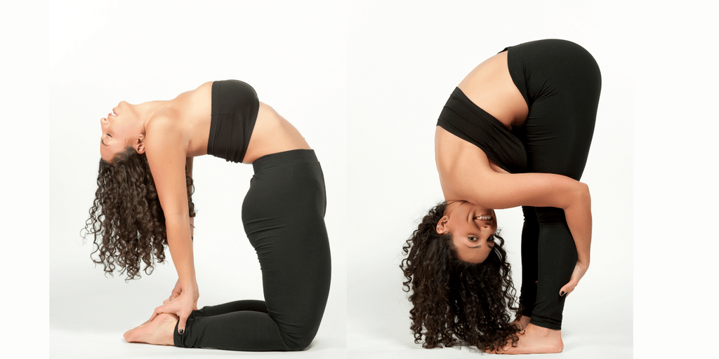Beautiful woman with dark brown curly hair wearing black yoga pants and a black bandau top working on a backbend yoga pose.