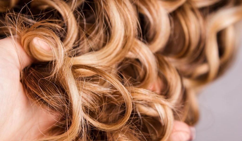 Close up of fingers detangling curly hair