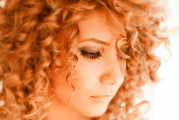 Young Latina woman with strawberry blonde curly hair portrait image