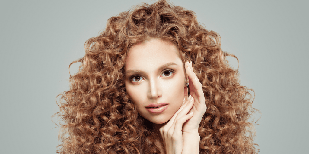 curly haired woman with hands on face