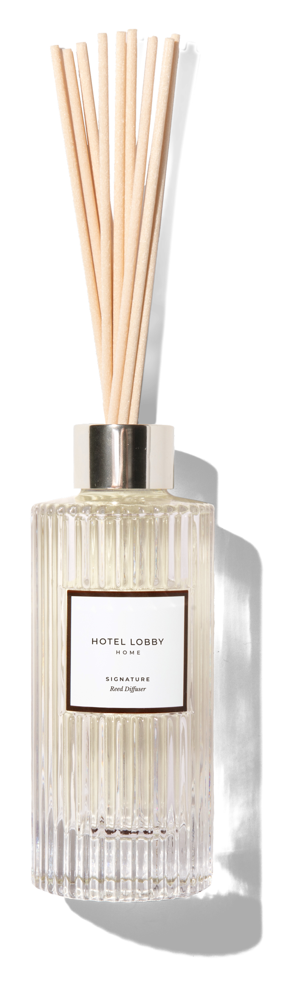 Reed diffuser in a ribbed glass bottle labeled 'Hotel Lobby Home Signature.'