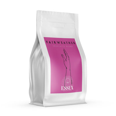 Image of coffee bag on white background. Coffee bag is white with pink sticker of half an arm shown on it. 