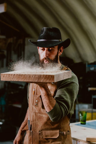 Zach blowing sawdust off walnut wood