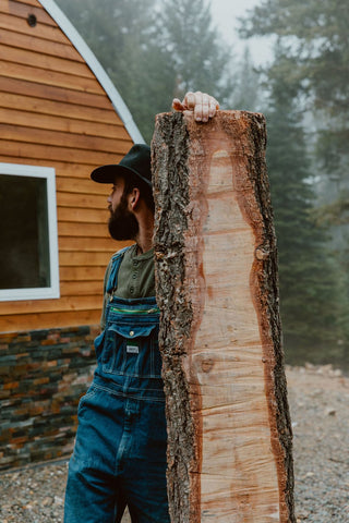 Zach holding wood in front of wood shop