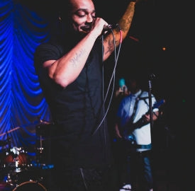 man on stage with a microphone smiling