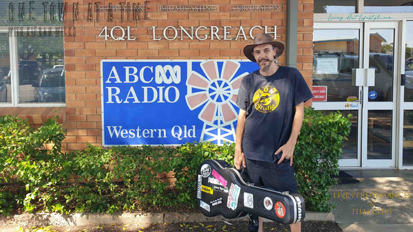 Kieran Wicks with his Cole Clark Guitar outside ABC Radio building in Longreach QLD