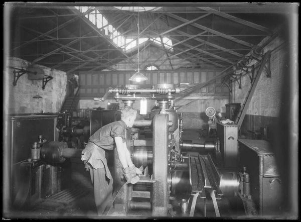 Man working with a rolling press at the Sydney Mint, Sydney, ca. 1920s 
