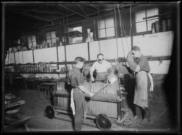 Men pouring metal for coins into tubes at the Sydney Mint Sydney ca 1920s