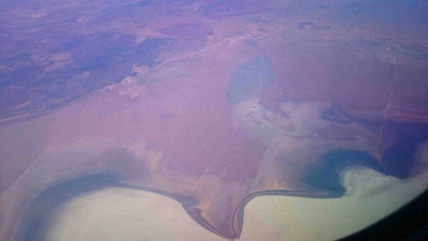 Aerial photography of Outback Australia Northern Territory near Darwin. Red Earth, scrub fires, rivers and raods carving through desolote terrain