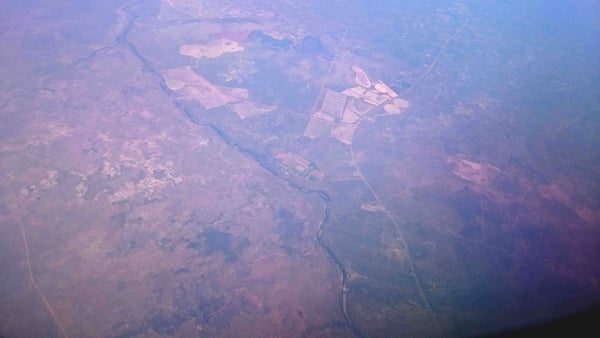 Aerial photography of Outback Australia Northern Territory near Darwin. Red Earth, scrub fires, rivers and raods carving through desolote terrain