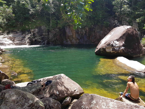 Kieran Wicks at on a granite rock on the edge of the swimming hole at Finch Hatton Gorge Wheel of Fire Rock Pool and Waterfall near Mackay Queensland. 