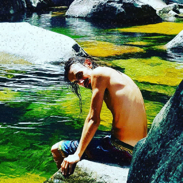 Kieran Wicks at on a granite rock on the edge of the swimming hole at Finch Hatton Gorge Wheel of Fire Rock Pool and Waterfall near Mackay Queensland. 