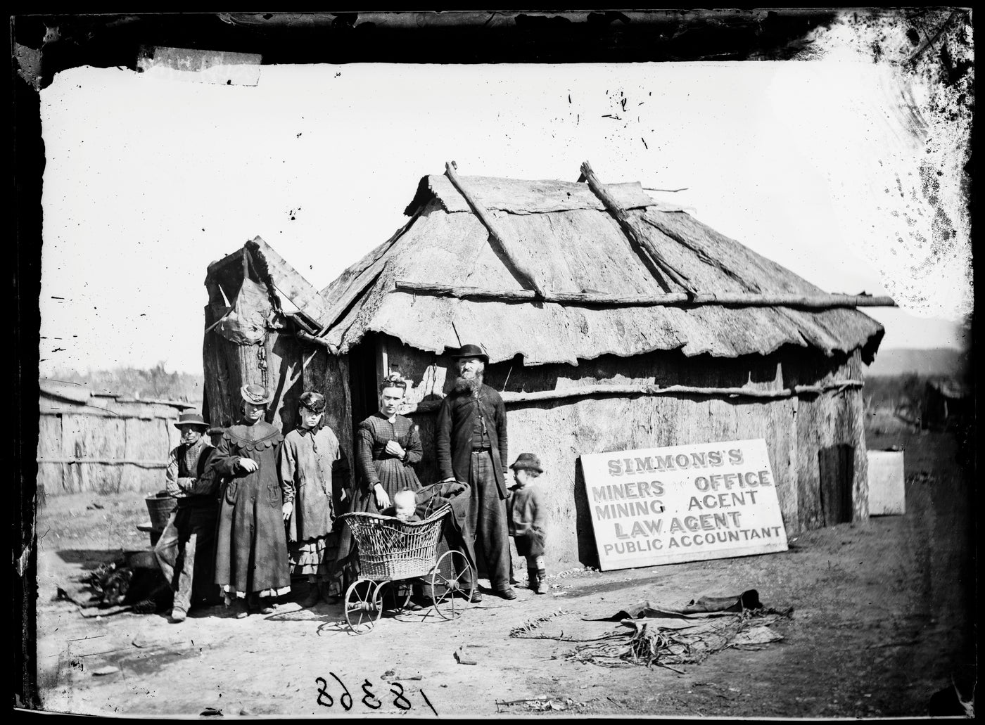 Simmons' miners' office, mining agent, law agent and public accountant) and family outside his bark hut, Gulgong area