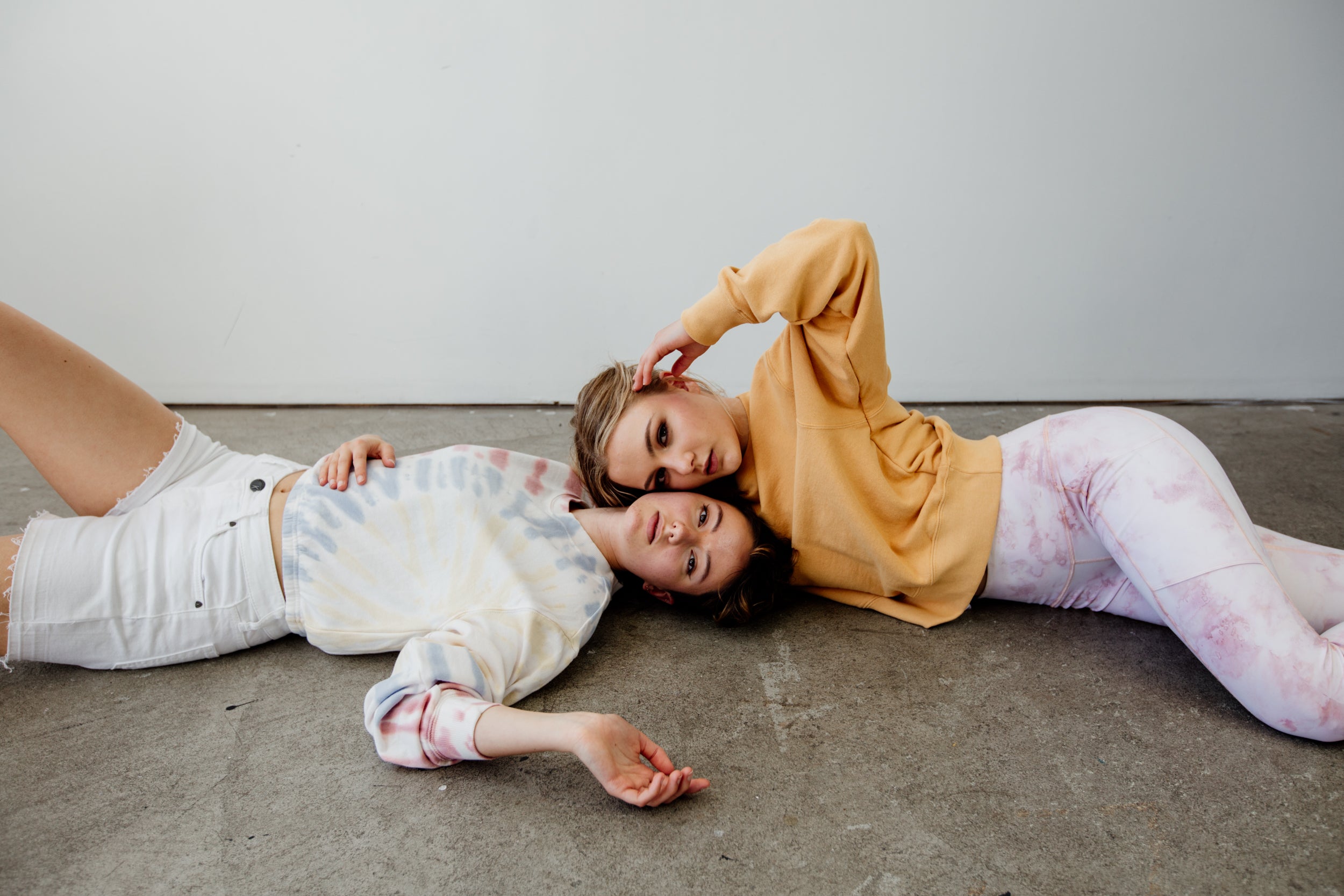 Two women lie on the floor
