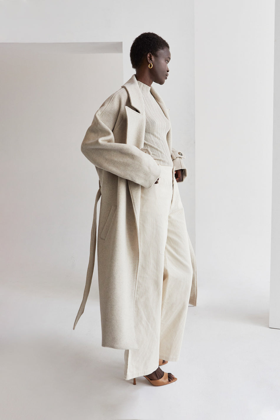 a model in a cream outfit with a beige wool coat